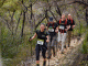 Image of an Oxfam Trailwalker team on a bush trail in single file all using trekking poles.