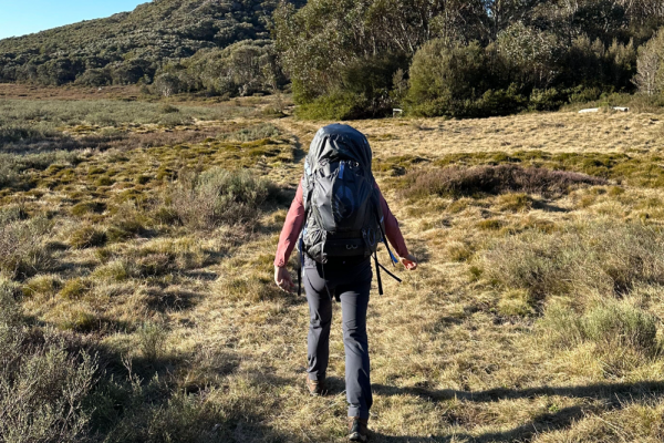 Girl walking through mountains wearing Osprey Aura AG